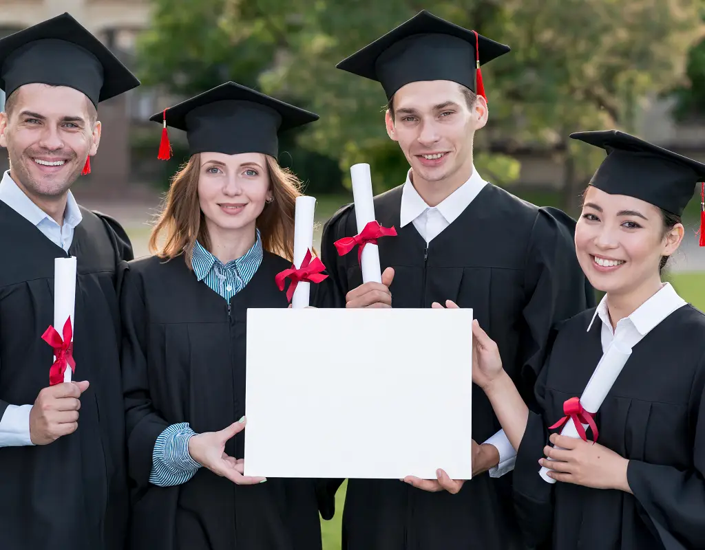 a group of people in graduation gowns holding a white sign